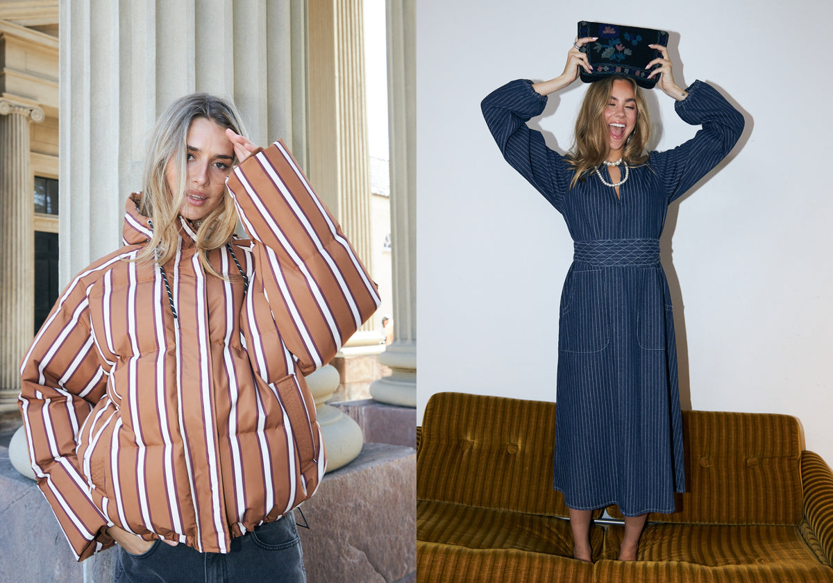 To kvinder i forskellige outfits. Den ene bærer en brun og lyserød stribet pufferjakke, mens den anden har en mørkeblå, nålestribet midikjole på og holder en broderet makeuptaske over hovedet.
