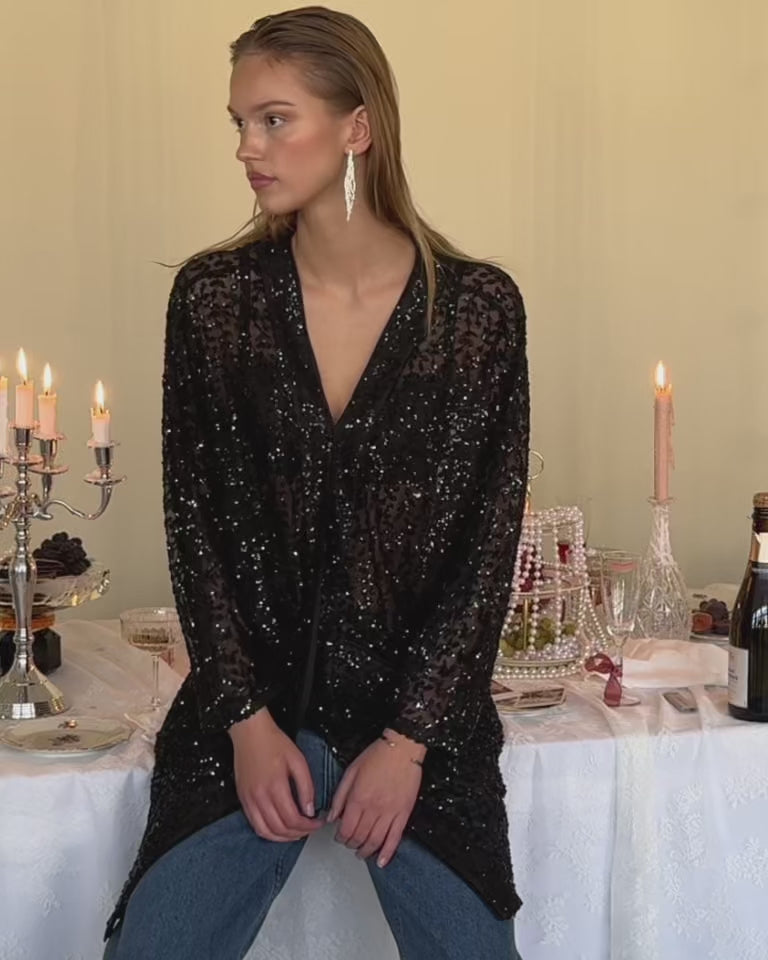 Video fra Lollys Laundry Pre-Spring Party 2026 kollektionen med glitrende feststyles, mørkeblå overdel, sorte pailletter og farverig blomstret skjorte.